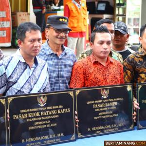 Bupati Hendrajoni berfoto dengan merk pasar yaang diresmikan. Humas Pessel