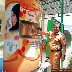 Kepala SMPN I Payakumbuh Devi Marlitdra mengambil air minum di smart water.