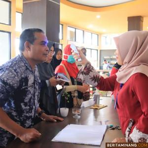 Petugas medis sedang ukur suhu tubuah Kepala DPMPTSP Payakumbuh Harmayunis.