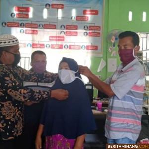 Petugas memasangkan masker produksi UMKM Solok Selatan kepada seorang warga. Foto Humas Solsel