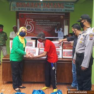 Ketua Dharma wanita Lapas Narkotika Sawahlunto Hj.Sunggusia Nasir menyerahkan paket sembako kepada salah seorang warga. Foto Iyos