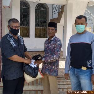 Kabag Kesra Setdakab Pesisir Selatan, Yoli Aang Syofria saat menyerahkan bantun pada Rustam garin Masjid  Almunawarah Nagari Koto Nan Duo Ampek Koto Hilie Kecamatan Batang Kapas. Foto Humas Pessel