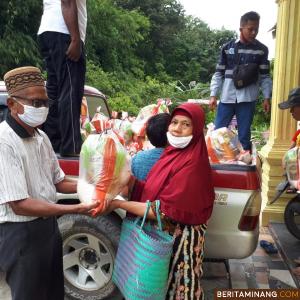 H.Zulkarnain saat menyerahkan paket kepada seorang ibu di Desa Sijantang, Jumat (8/5). Foto Iyos