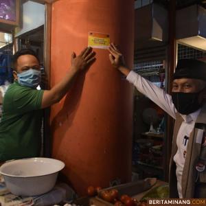 Wako Mahyeldi saat tempel stiker di kios pedagang Pasar Raya Padang yang sudah lakukan tes swap Virus Corona. Foto Prokompim Padang
