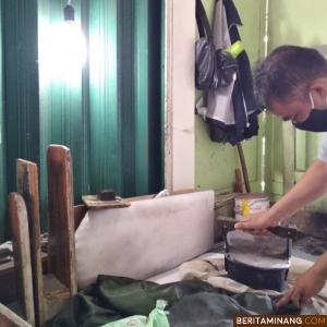 Pak Anjas seorang penjual jasa strika arang di Pasar Padang Panjang sedang menjalani permintaan konsumen. Foto Kominfo Padang Panjang