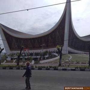 Seorang warga melintas di Jalan Khatib Sulaiman Padang, Minggu (25/10/2020) dengan latar belakang Masjid Raya Sumbar yang kini jadi pusat Kendali MTQ Nasional XXVIII. Foto: Rokcalva