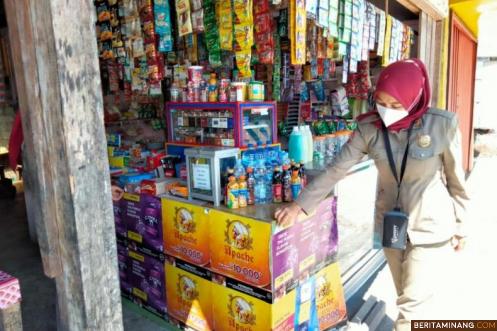 Satpol PP Damkar Kota Padang Panjang ketika menertibkan iklan rokok di warung, Sabtu (19/06).