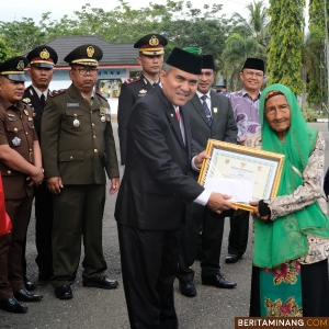 Sekda Dharmasraya, Adlisman serahkan bingkisan usai bertindak sebagai Pemimpin Upacara pada Peringatan Hari Pahlawan ke-79 Tahun 2024 dan Hari Kesehatan Nasional ke-60. Upacara ini dilaksanakan di halaman kantor Bupati Dharmasraya, pada hari Minggu, (10/11/2024). Foto: Kominfo Dharmasraya
