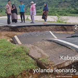 Warga sedang mengamati kondisi akses Jalan Provinsi di Kabupaten Pesisir Selatan, yang terputus total akibat banjir, Senin (2/12/2024). Foto: BPBD Pesisir Selatan