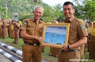 Sekretaris Kabupaten (Sekkab) Pessel, Mawardi Roska saat menyampaikan penghargaan ke Kepala Badan Kepegawaian Pengembangan Sumber Daya Manusia (BKPSDM) Kabupaten Pesisir Selatan (Pessel), Yoski Wandri, Jumat (3/1/2025). Foto: Kominfo Pessel