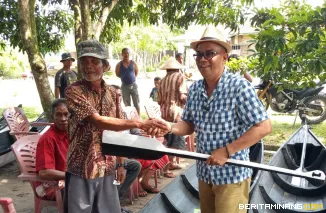 Walinagari  Katiagan  Endang Putra ( Kiri) Menyalurkan Perahu Kepada Salha seorang Nelayan penerimaan Manfaat Program ketahanan Pangan Katiagan. Sabtu, 19/7/2025. Foto : E