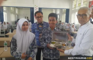 Kepala Dinas Perikanan dan Ketahanan Pangan Kota Padang, Alfiadi serahkan MBG ke siswa dalam dilaunching pemberian MBG dapur SPPG Rangkiang Minang di SMPN 13 Padang, Rabu (1/10/2025). Foto-Foto: Rokcalva